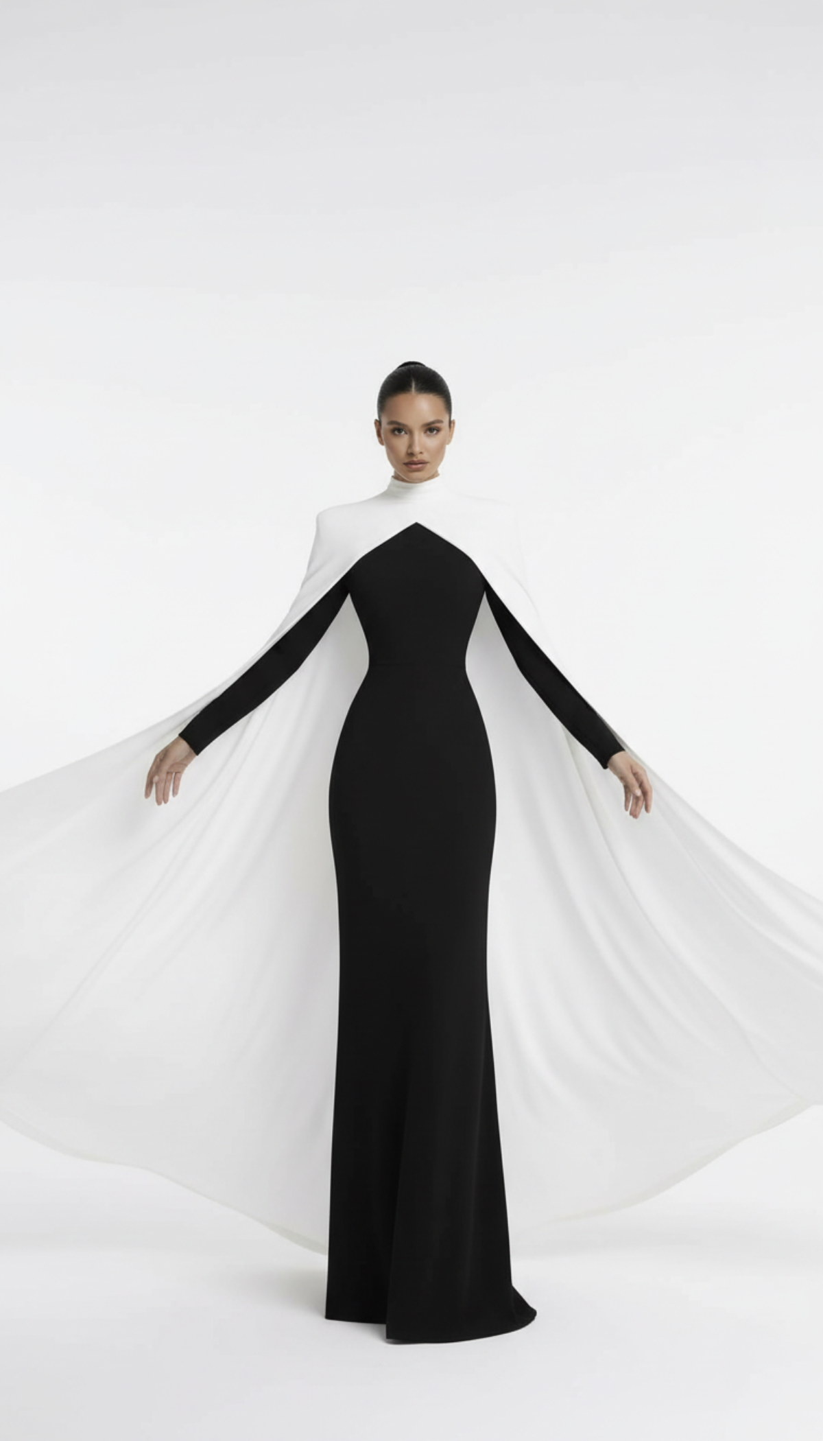 Woman wearing a black and white dress with a cape on a white background