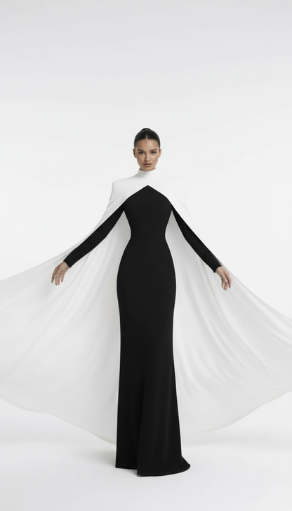 Woman wearing a black and white dress with a cape on a white background