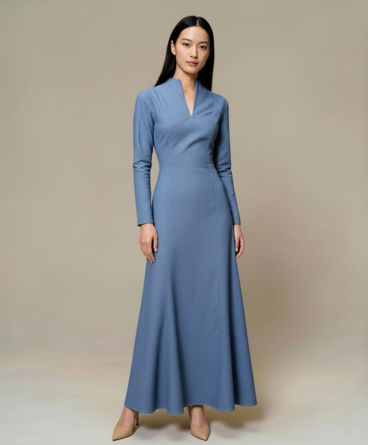 Long blue denim maxi dress with long sleeves and a clean, structured silhouette, photographed front view.