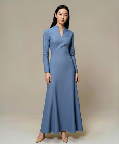 Long blue denim maxi dress with long sleeves and a clean, structured silhouette, photographed front view.