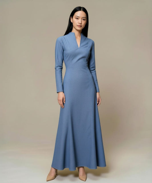 Long blue denim maxi dress with long sleeves and a clean, structured silhouette, photographed front view.