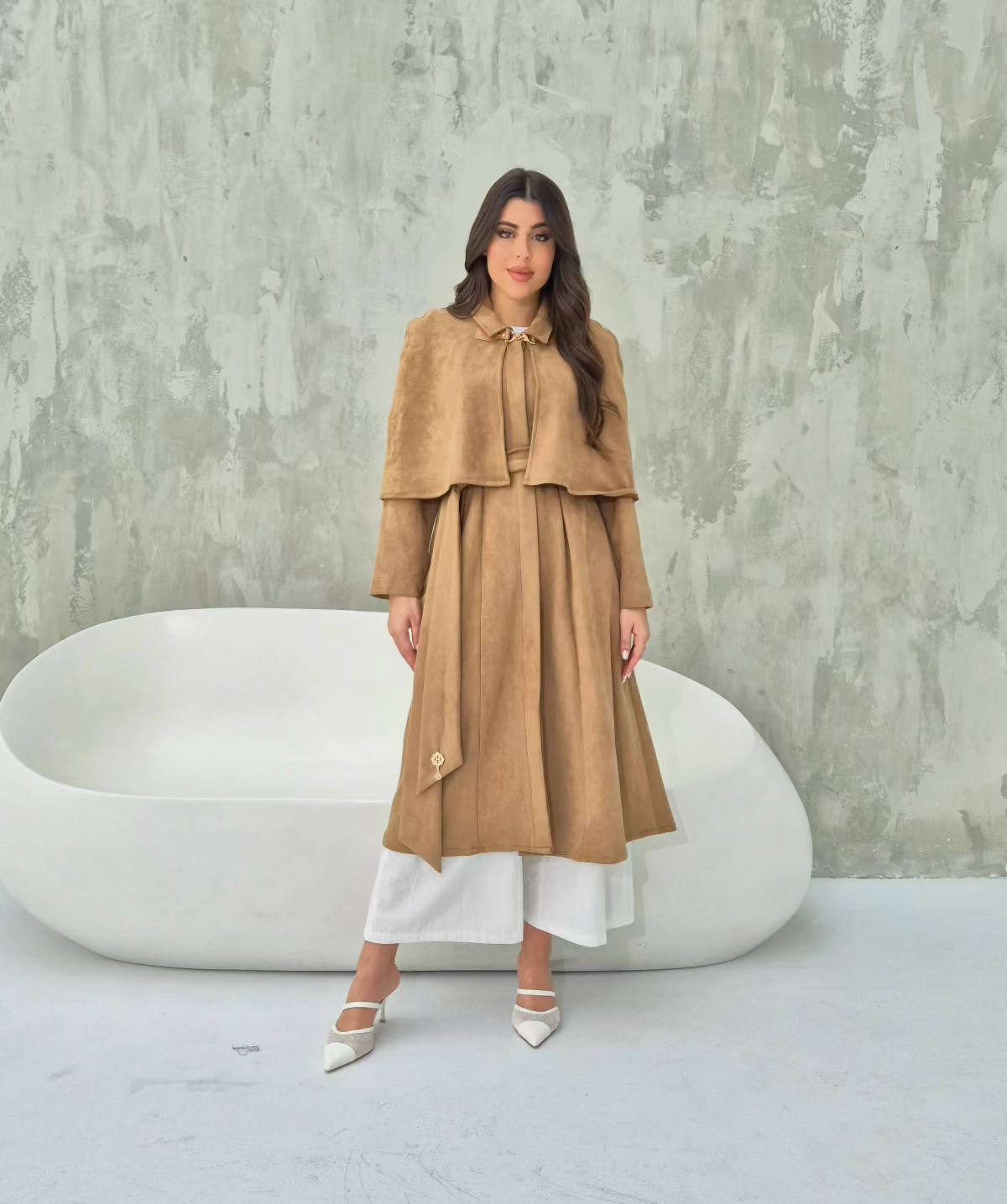 Model wearing convertible suede camel cape coat with detachable short cape for a chic layered look